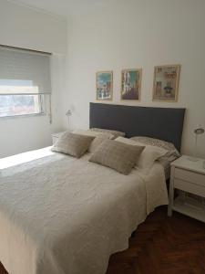 罗萨里奥Moderno Depto Pleno Centro的卧室内的一张大白色床,带有窗户