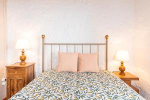 Calheta de NesquimLobo do Mar的一间卧室配有一张床、两个床头柜和两盏灯。