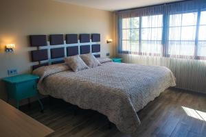 拉伊鲁埃拉阿罗亚梅恩托诺哈尔公寓的一间卧室配有一张大床和蓝色床头板