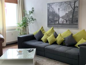 奥尔登堡TOP-Zentrum Fußgängerzone, 81 qm, Küche, Parkplatz的客厅配有带黄色和蓝色枕头的沙发