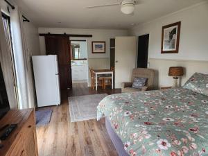 史丹霍普Spencer Lane Cottage & Granny Flat的一间卧室配有一张床、一台冰箱和一张桌子