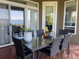 基洛纳湖景加花园景豪华别墅的一间设有玻璃桌和椅子的用餐室