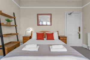 爱丁堡Marchmont Traditional Apartments的一间卧室配有一张带红色枕头的大床