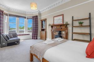 爱丁堡Marchmont Traditional Apartments的一间卧室配有一张床、一把椅子和一个壁炉