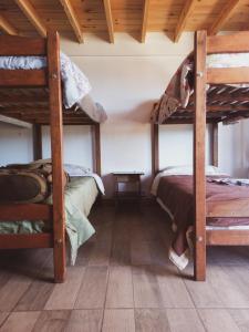 特来凡林Hostel Luan Posada de Montaña的一间卧室设有两张双层床和木制天花板。