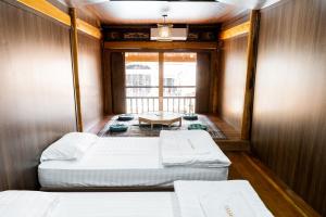 河江Odyssey Hostel, Tours & Motorbikes Rental的小房间设有两张床和一张桌子