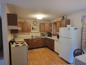 西南港Kenway Ranch的厨房配有白色冰箱和木制橱柜。