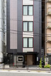 东京Section L Yushima-Ueno的一座高大的黑色建筑,前面有标志