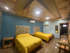 克雷尔Cabañas Rochivo Ranch的配有黄色床单的客房内的两张床