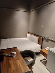 台北璞乐米窝的一间卧室配有一张床和一张桌子及椅子