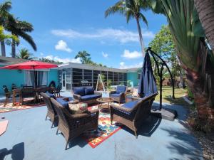 皮尔斯堡Beach & Surf Hacienda on Hutchinson Island的庭院配有椅子、遮阳伞和桌子。