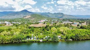 贡布Kampot Riverfront Boutique的水中的一个岛屿,有城镇和山脉