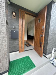 名户The Ritz Okinawa Kise 2的浴室位于门前,配有绿色垫子