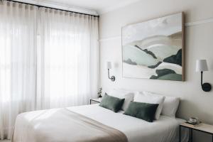 莫斯谷道儿米房屋酒店的一间卧室配有带白色床单和绿色枕头的床。