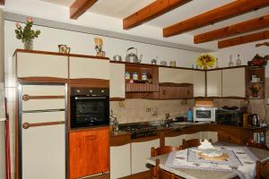 蒙切尼肖Chalet del paese Incantato的厨房配有白色橱柜和带桌子的西德克斯茶桌。