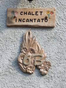 蒙切尼肖Chalet del paese Incantato的读查cantato的沙锥网和墙上的花的标志