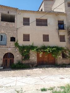 莱图尔Casa Rural Juan, el Zapa的旧石制建筑,设有上板的窗户和门