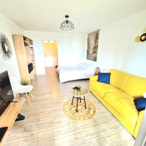 圣吉尔莱班Studio P'ti Boucan的客厅配有黄色的沙发和床。