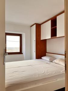 法扎纳Apartments Zukanovic的一间卧室配有一张带白色床单的大床