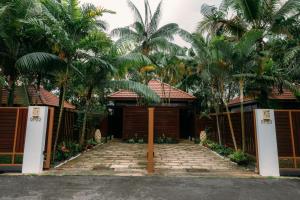 新加坡Kranji Sanctuary Resort的一座带大门和棕榈树的房子