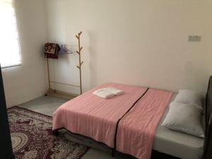 丰盛港Rasa Sayang Homestay Mersing的小卧室配有一张带粉色毯子的床