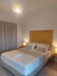 普拉提伊亚洛斯西弗诺斯Irini pension的一间卧室配有一张带两盏灯的大型白色床。