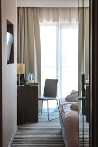 博茨科沃Antonińska Resort SPA的酒店客房配有一张床、一张桌子和一把椅子。