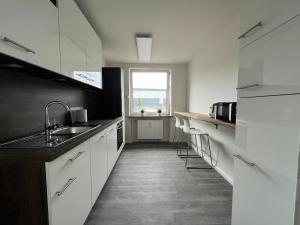 汉堡"Live Good, Work Good"- Central Apartment by GG Rental Hamburg的厨房配有白色橱柜、水槽和窗户。
