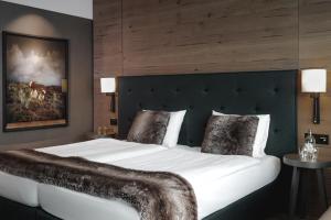 达沃斯美隆达沃斯瑞士山庄度假酒店的卧室配有一张白色大床和床头板