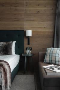 达沃斯美隆达沃斯瑞士山庄度假酒店的一间卧室配有一张床、一张桌子和一张沙发