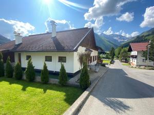 贝旺Alpin Haus Berwang的街上的白色房子,屋顶是棕色的