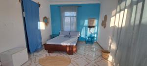 帕杰Karibu House的一间卧室设有一张床和蓝色的墙壁