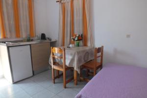 锡米Anastasia Apartments (Chorio)的厨房配有带2把椅子的桌子和水槽