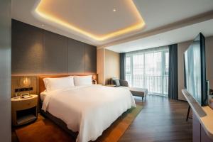 深圳深圳憬居酒店的酒店客房,配有床和电视