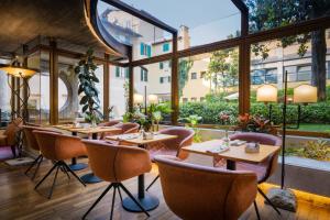 佛罗伦萨克罗齐迪马耳他酒店的餐厅设有桌椅和大窗户。
