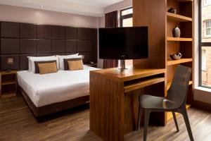 利兹利兹市罗姆兹酒店的酒店客房,配有床和电视