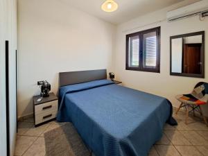 圣特奥多罗Appartamento Trilocale vicino al centro di San Teodoro的一间卧室设有蓝色的床和窗户。