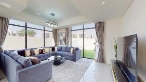 迪拜Primestay - Odora 6BR, Akoya Oxygen的客厅配有蓝色的沙发和电视