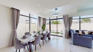 迪拜Primestay - Odora 6BR, Akoya Oxygen的一间带桌椅和沙发的用餐室