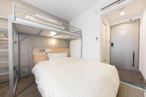 东京东京大冢超级酒店 的卧室配有一张白色大床
