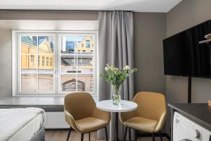 奥斯陆numa I Hallen Apartments的酒店客房设有桌椅和窗户。
