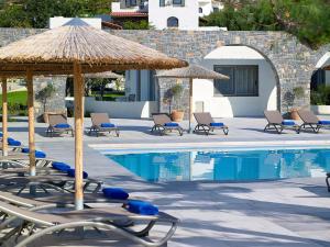 考特索纳里Coriva Beach Hotel & Bungalows的一组椅子和遮阳伞,位于游泳池旁