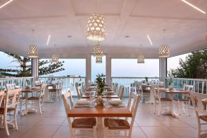 考特索纳里Coriva Beach Hotel & Bungalows的用餐室设有桌椅和窗户。