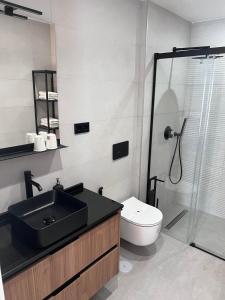 福恩吉罗拉Apartamentos Kouohana的一间带水槽、淋浴和卫生间的浴室