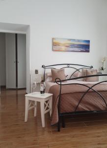 奇维塔韦基亚Guest house al mare的一间卧室配有一张床和一张桌子及一瓶葡萄酒
