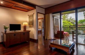 琅勃拉邦La Résidence Phou Vao, A Belmond Hotel, Luang Prabang的带电视的客厅和阳台。