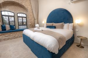 萨法德Moses Luxury Vacation Homes-מתחם פיניקס的一间卧室配有一张大床和蓝色床头板