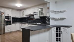 坎普朗莫道尼斯Casa Diana&Ovi的厨房配有白色橱柜和黑色台面