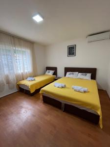 斯塔多伊兰Villa Utopia的配有黄色床单的客房内的两张床
