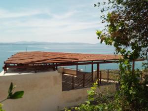 圣加利尼Loggia的一座有屋顶的建筑,以海洋为背景